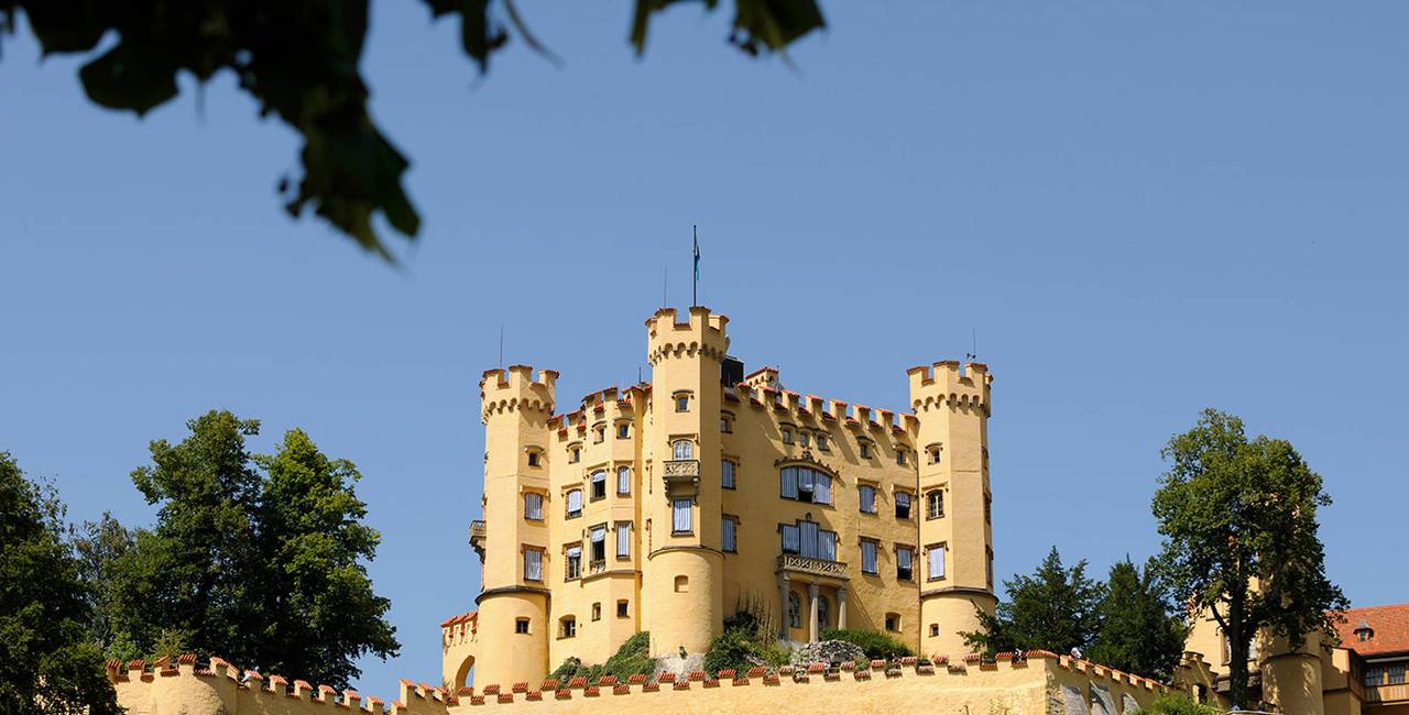 Blick auf Schloss Hohenschwangau bei strahlend blauem Himmel